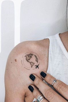 a woman's arm with a small world map tattoo on the left side of her arm