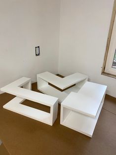 three white tables sitting in an empty room