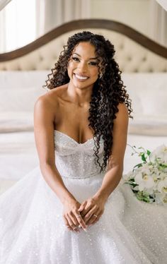 a woman in a wedding dress sitting on a bed