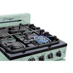 a green stove top oven with two burners and one light on the front, against a white background