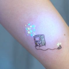 a small tattoo on the arm of a woman's arm with an image of a computer