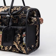 a black and gold floral bag with handles