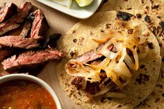 steak, tortillas and salsa on a cutting board