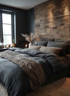 a large bed sitting next to a window in a room with black walls and wooden headboard