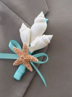 a boutonniere decorated with starfish and seashells on a gray suit