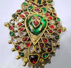 A beautiful Vintage turban pin or Pendant from Rajasthan, encrusted with old mine cut Diamonds, Rubies, Emeralds set in 20 carats solid Gold and back adorned with multicolor enamel exquisite work, Detailed Kundan Meen work an Original classic collector's piece which could be easily adopted into two individual pendants or Brooch and a pendant. very versatile piece in good condition. Size of piece-11/4.5 cm, total weight-54 grams(2.94). Material-solid 20 carat gold and natural genuine Gemstones. Traditional Jeweled Tikka For Celebrations, Traditional Ceremonial Brooch Jewelry, Festive Brooch Jewelry, Traditional Wedding Brooch Jewelry, Traditional Brooch With Intricate Design As Gift, Traditional Brooches With Intricate Design For Gifts, Traditional Brooches With Intricate Design As Gift, Jeweled Temple Jewelry Tikka As Gift, Traditional Green Brooch Jewelry