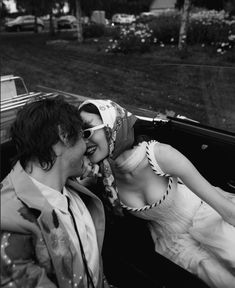 a man and woman sitting in the back of a car