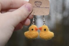 a pair of small yellow birds hanging from earwires in front of a card