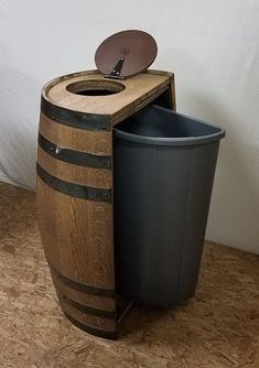 a trash can is next to a wooden barrel