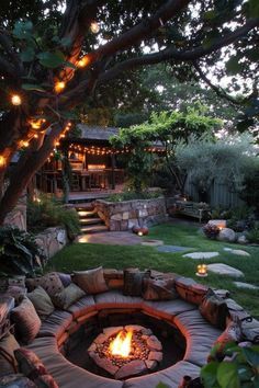 an outdoor fire pit surrounded by rocks and lights