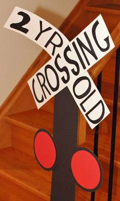 a sign that is on the side of a wooden stair rail with red circles around it