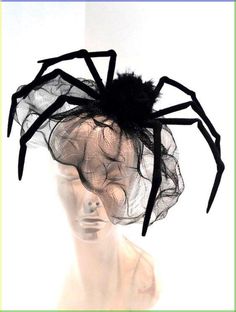 there is a spider on the top of a mannequin's head with black netting