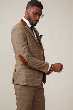 Inspired by old age country wear, the DX7 suit remains an ever so popular style, reminiscent of the 18th century. It is ideal for Autumn/Winter with its earthy colour palette and heavy fabric. A touch of modernism is added with a velvet contrast collar, elbow pads and pocket trims, nudging it back into the 21st century. Perfect for a rustic countryside wedding. Mix-and-match the waistcoat to differentiate from the groomsmen and match your accessories with the bridesmaid dresses. Looking for a pl Brown Tweed Suit With Herringbone Pattern, Elegant Brown Tweed Sport Coat, Tailored Brown Tweed Jacket With Notch Lapel, Brown Tweed Jacket With Herringbone Pattern And Suit Collar, Tailored Brown Single-breasted Tweed Jacket, Brown Tweed Jacket With Herringbone Pattern, Brown Tweed Jacket With Suit Collar, Brown Tweed Jacket For Tailoring, Brown Single-breasted Suits For Fall