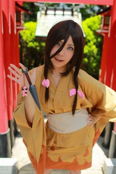 a woman in an orange kimono holding a pair of scissors and wearing pink hearts on her fingers