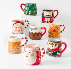 christmas themed coffee mugs on display in front of a white background with holiday decorations