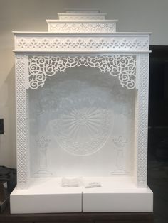 an intricately carved white fireplace screen on display