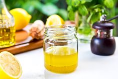 a glass jar filled with liquid next to sliced lemons