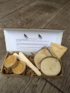 an open box with wooden spoons and jars