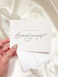 a person holding two cards with the words will you be my bridesmaid?