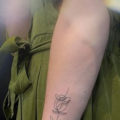 a woman's arm with a tattoo on the left side of her arm and a flower in the middle