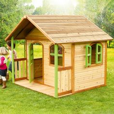 two children playing in a wooden play house with green trimmings on the roof