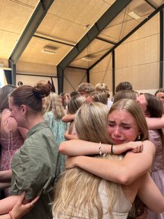 two girls hugging each other in a crowd