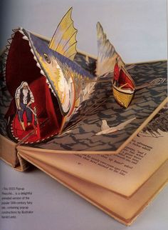 an open book with some paper boats on it