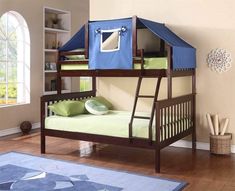 a bunk bed with a blue tent over it and green pillows on the bottom floor