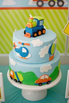 there is a blue cake with cars and trucks on it