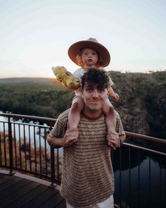 a man holding a small child on his shoulders