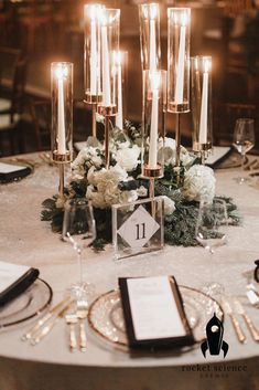 the table is set with candles, flowers and menus for an elegant wedding reception