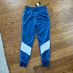 Deep Blue And White Retro Style Track Pants. Blue Stretch Joggers For Spring, Spring Stretch Blue Joggers, Fitted Blue Joggers With Pockets, Navy Nike Bottoms For Loungewear, Nike Navy Bottoms For Loungewear, Nike Navy Loungewear Bottoms, Nike Blue Loungewear Bottoms, Nike Blue Bottoms With Elastic Waistband, Blue Sporty Tapered Leg Bottoms