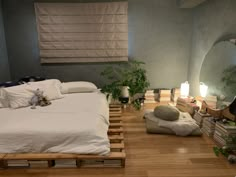 a bed room with a neatly made bed and wooden pallets on the floor next to it