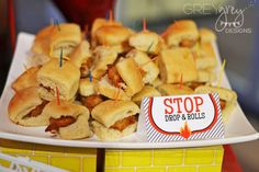 small sandwiches with toothpicks on them sitting on a white plate in front of a yellow brick wall