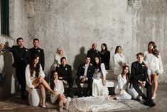 a group of people posing for a photo in front of a wall with white walls