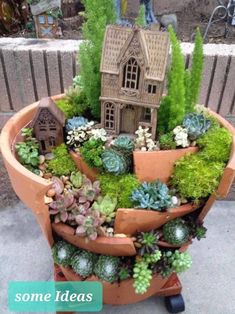 a potted planter filled with succulents and a house in the middle