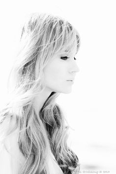 a black and white photo of a woman with long hair looking off to the side