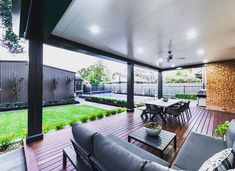 an outdoor living area with wooden flooring and large glass doors leading to the back yard