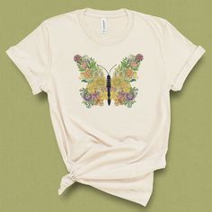 This unique butterfly floral Shirt, has a vintage botanical feel to it, with an intricate flower design. This cute boho shirt, makes a great gift for mom, for mothers day, gift for her or gift for the garden lover. This shirt is great for a warm spring or summer day, a festival, brunch or afternoon in the garden. DETAILS This Beautiful graphic t-shirt is made of 49% to 100% combed and ring-spun cotton and is very soft and comfortable to wear. Check the size card for specific fabrications per col Bohemian Cotton Tops With Butterfly Print, Floral Print Summer Tops As A Gift, Spring Printed Tops For Gift, Floral Print Tops For Summer, Printed Tops For Spring Gift, Printed Tops For Spring, Multicolor T-shirt For Spring Gift, Floral Print T-shirt For Spring Gift, Multicolor Tops For Spring As A Gift