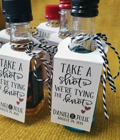 three small bottles with labels on them sitting on a table