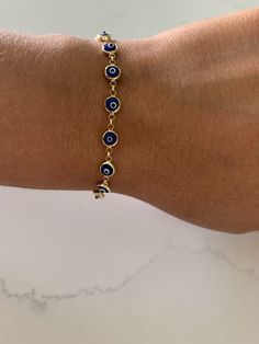 This 14K Gold Evil Eye Bracelet is an ideal accessory for daily wear, crafted from 14K solid gold with a glass blue eye. Make a lasting impression with the perfect gift for yourself or a loved one. The bracelet is available in a classic blue shade, delivering an iconic look. ♦ Materials: 14K Yellow God, Glass Blue Eye ♦ Available color: Blue evil eye ♦ Bracelet Measurements: Bracelet is 6 MM thick and 7.5" length, average weight 7.2grams, it does have a lobster clasp not a spring ring----------- Everyday Blue Tarnish-resistant Jewelry, Blue 14k Gold Everyday Bracelets, Everyday Blue 14k Gold Bracelets, Yellow Gold Round Evil Eye Bracelet, Everyday Blue Evil Eye Jewelry, Hypoallergenic Gold Plated Blue Jewelry, Blue Hypoallergenic Round Bracelets, Hypoallergenic Blue Round Bracelets, Hypoallergenic Blue Gold-plated Jewelry