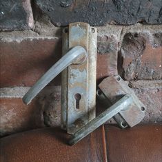 an old door handle is attached to a brick wall