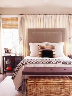 a bedroom with a large bed and wicker baskets on the nightstands next to it