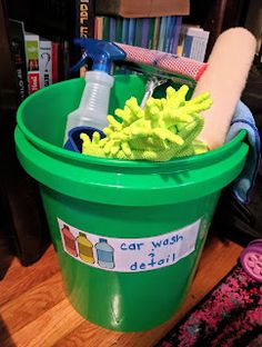 a green bucket filled with cleaning supplies on top of a wooden floor