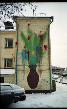 a large painting on the side of a building with flowers in vases painted on it