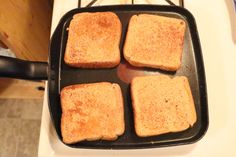 four pieces of toasted bread sitting on top of a black grilling pan over a stove