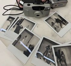 a camera sitting on top of a table next to some polaroids and pictures