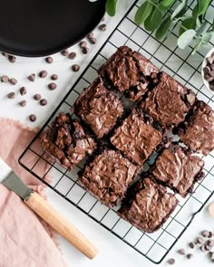 chocolate brownies on a cooling rack next to coffee beans