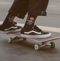 the feet of a skateboarder wearing black and white socks with an image of a man's face on it