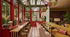 a room filled with lots of furniture and plants inside of it's walls covered in windows